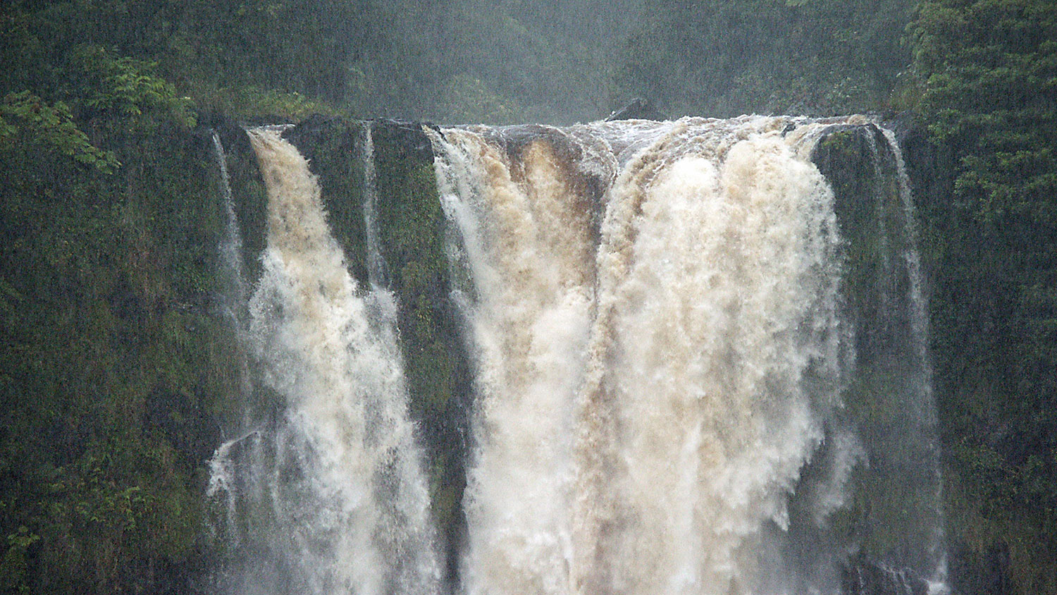 Large Water Fall Surrounded by Green Cliffs
